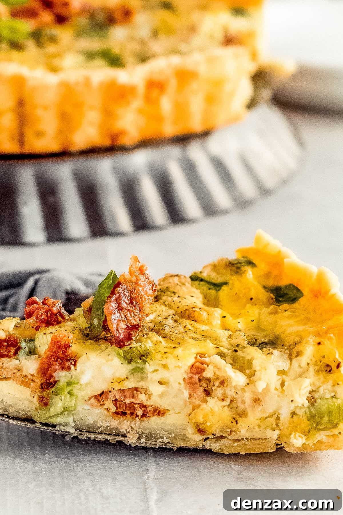 A Close-Up Shot of a Slice of Bacon Quiche Lorraine on a Metal Serving Spatula