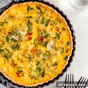 A Bacon Quiche Lorraine Beside a Gray Tablecloth and a Glass of Water