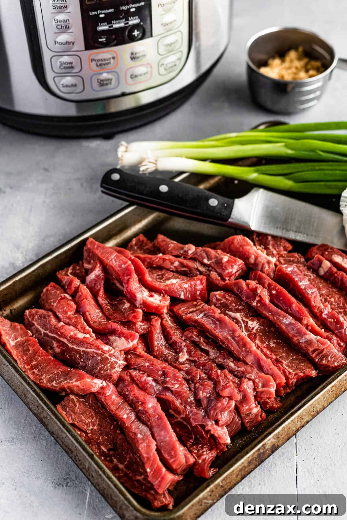 Green Onions, Garlic, Soy Sauce, Slices of Flank Steak and the Rest of the Ingredients on Two Different Baking Sheets