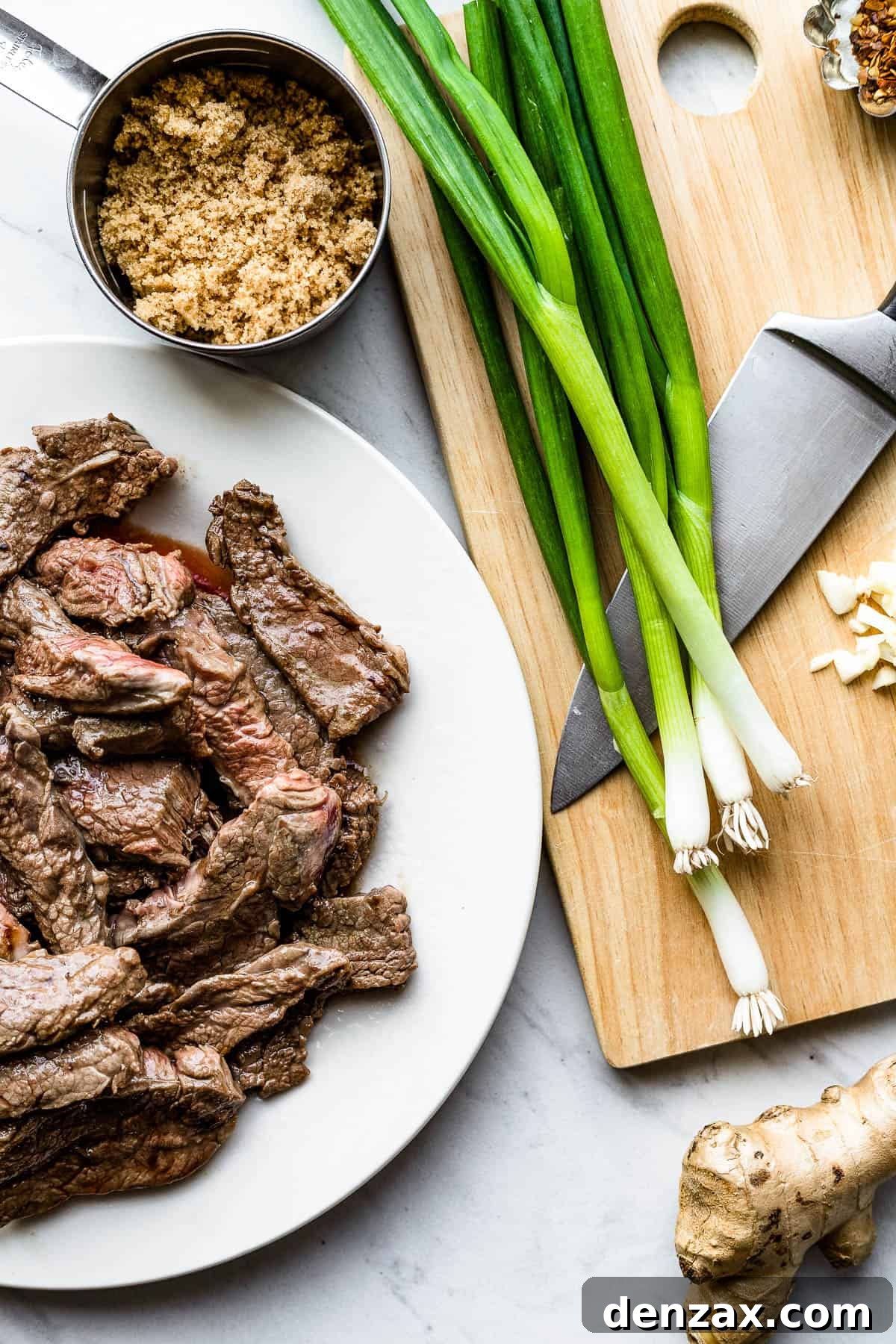 Green Onions, Garlic, Soy Sauce, Slices of Flank Steak and the Rest of the Ingredients on Two Different Baking Sheets