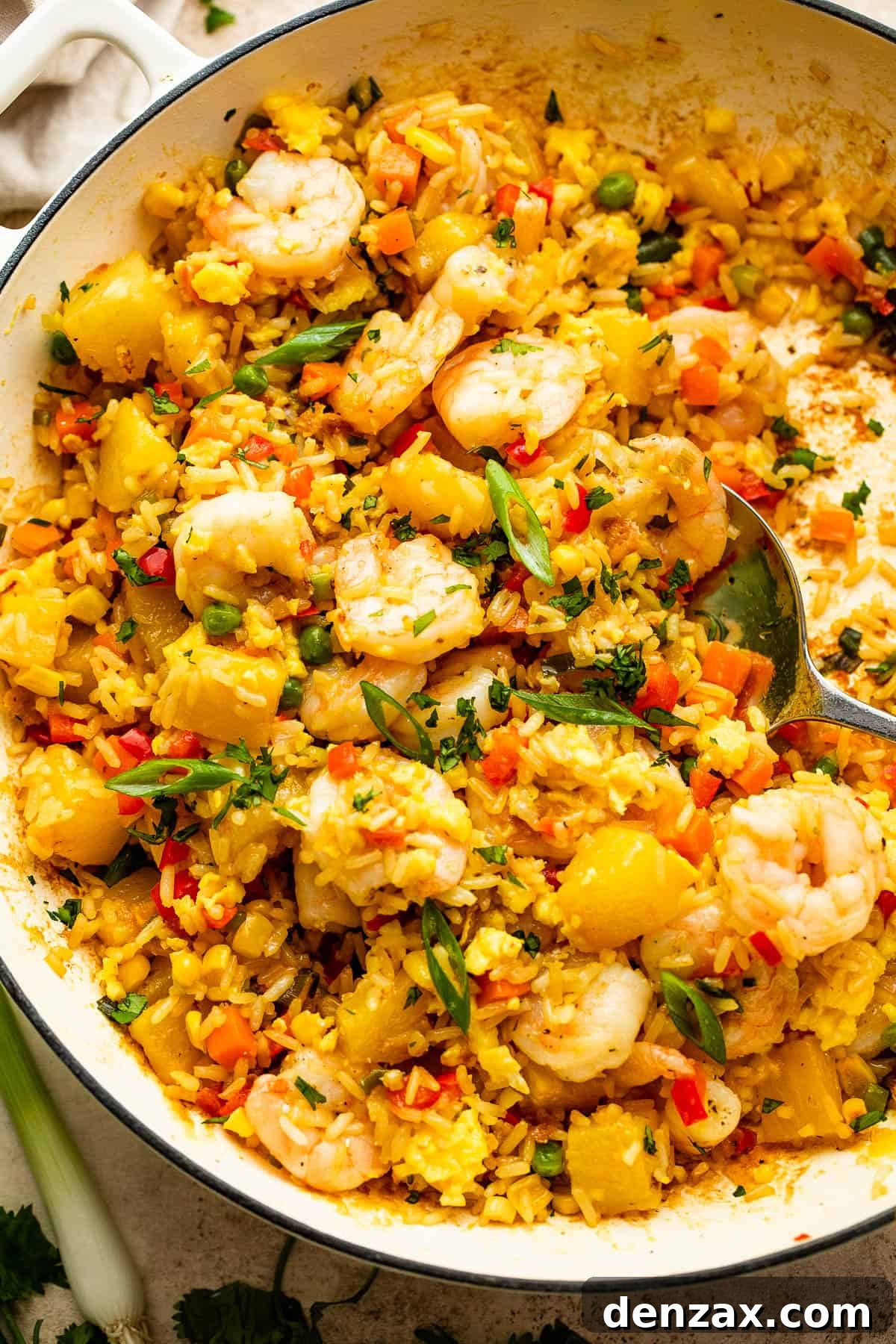 White cast iron skillet with Shrimp Fried Rice and pineapple chunks