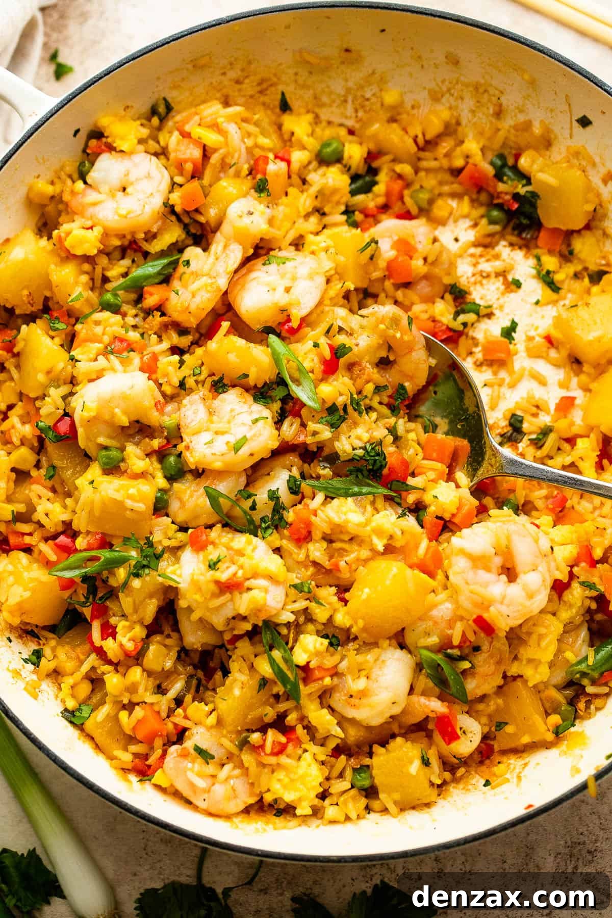 White cast iron skillet with Shrimp Fried Rice and pineapple chunks
