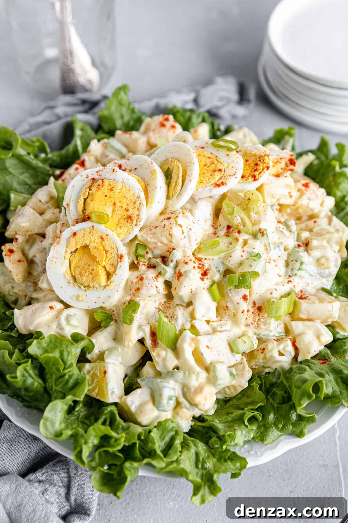 A Big Plate of Salad with Smaller Plates Stacked in the Background
