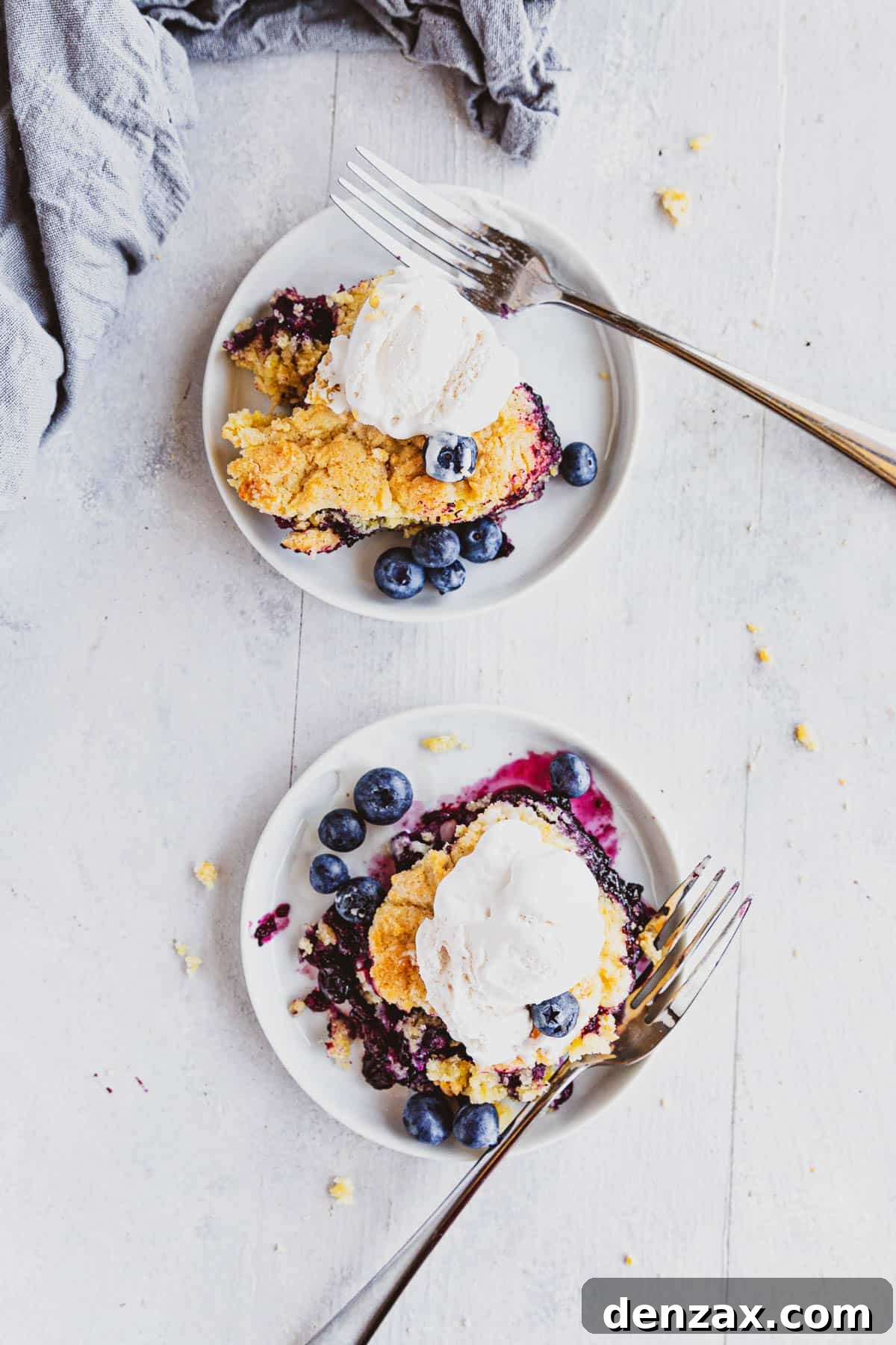 overhead view of two white plates with Blueberry Rhubarb Cobbler