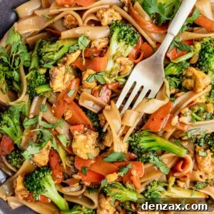 A Fork Digging Into a Big Plate of Pad See Ew