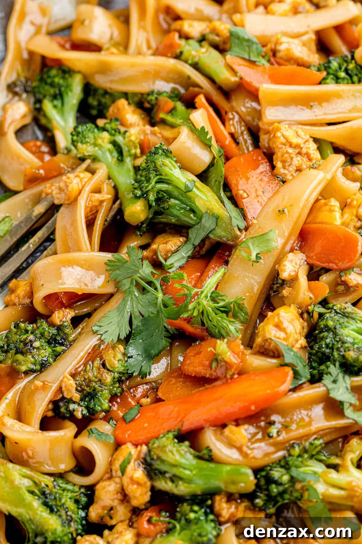 A Super Close-Up Shot of Pad See Ew with a Fork Peeking Through in the Corner