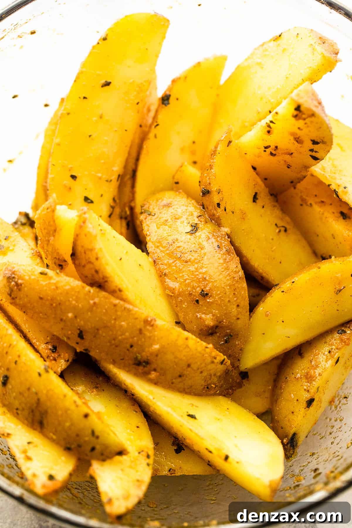 Cut up russet potatoes in a glass bowl.