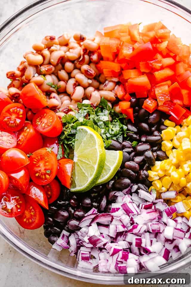 avocado, corn, tomatoes, black-eyed peas, beans and cilantro in a large glass bowl