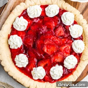 overhead shot of strawberry pie garnished with dollops of cream