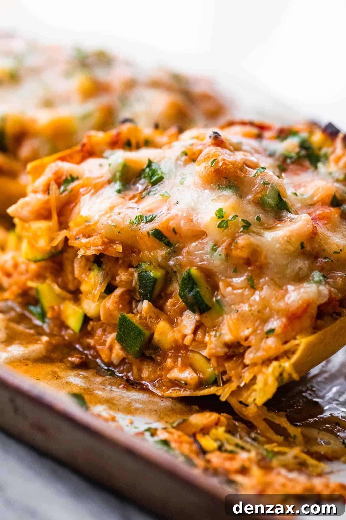 halved spaghetti squash stuffed with chicken enchilada filling and topped with melted cheese