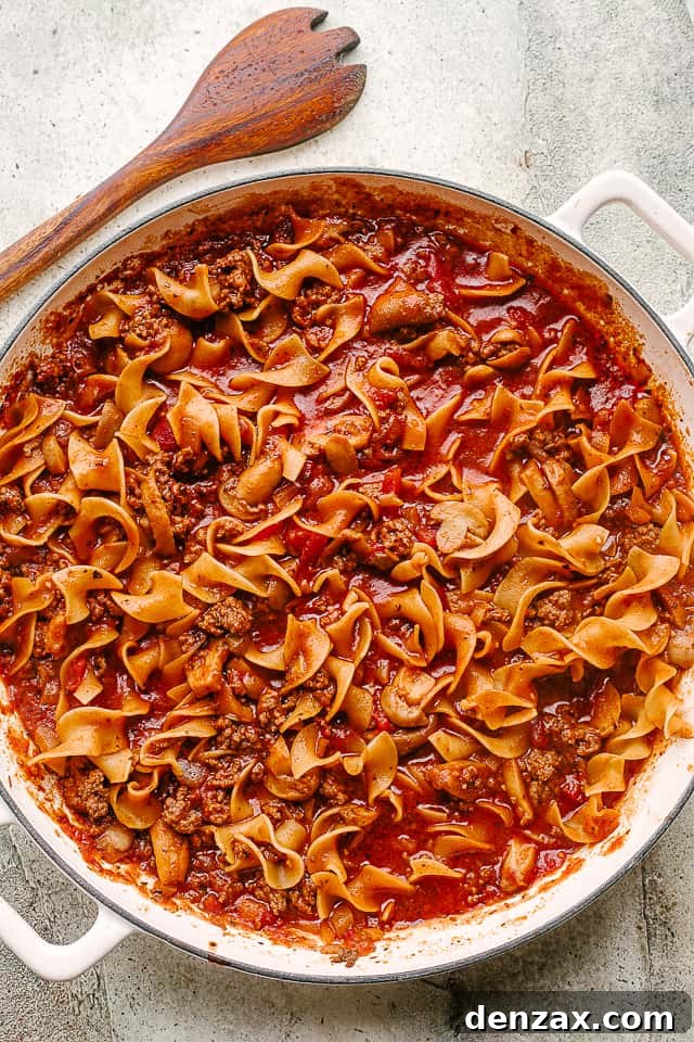 Meat, noodles, and sauce cooking together meat, noodles, and pasta sauce cook in a skillet