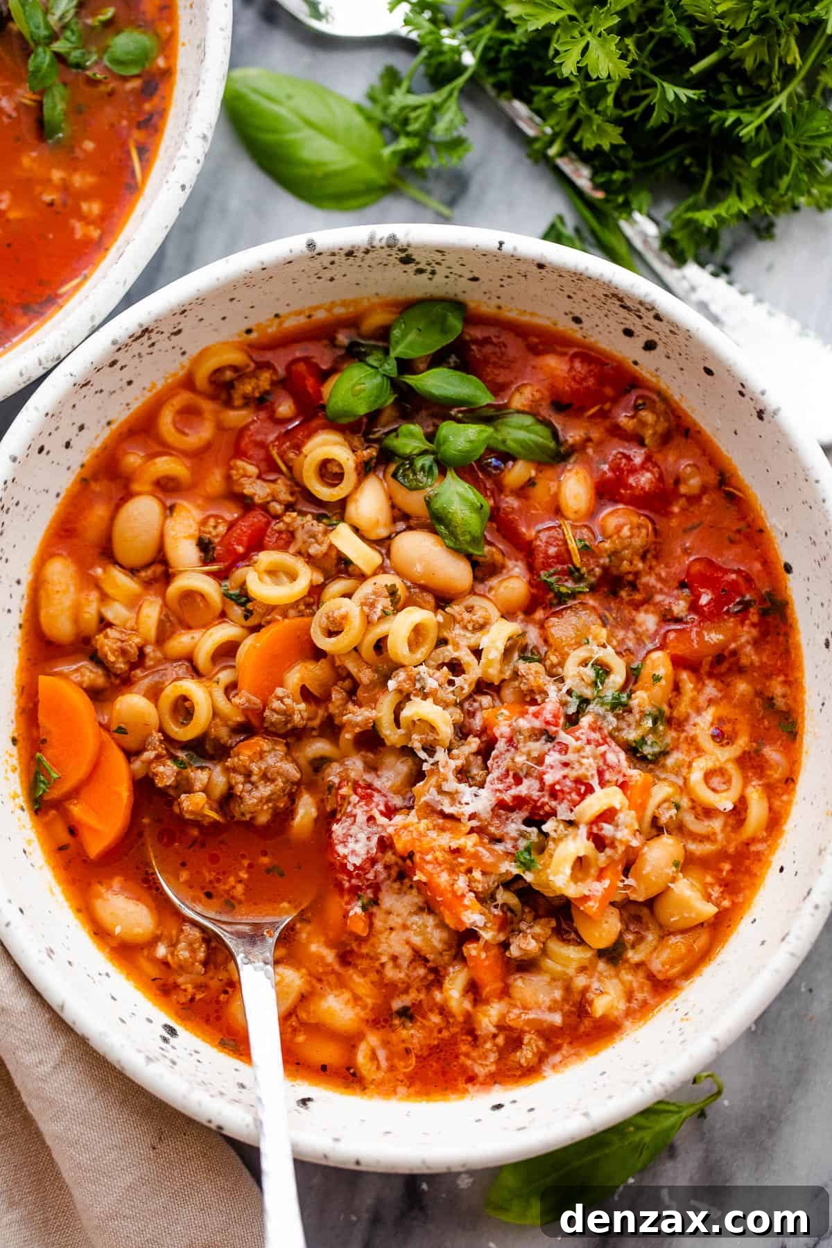 overhead shot of pasta fagioli served in a bowl with a spoon