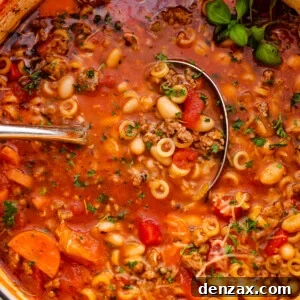 pasta fagioli soup in a white dutch oven with ladle inside the soup