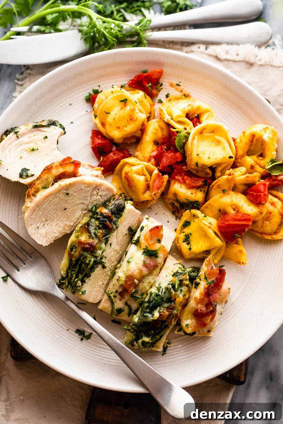 cut up stuffed chicken breast served alongside tortellini pasta