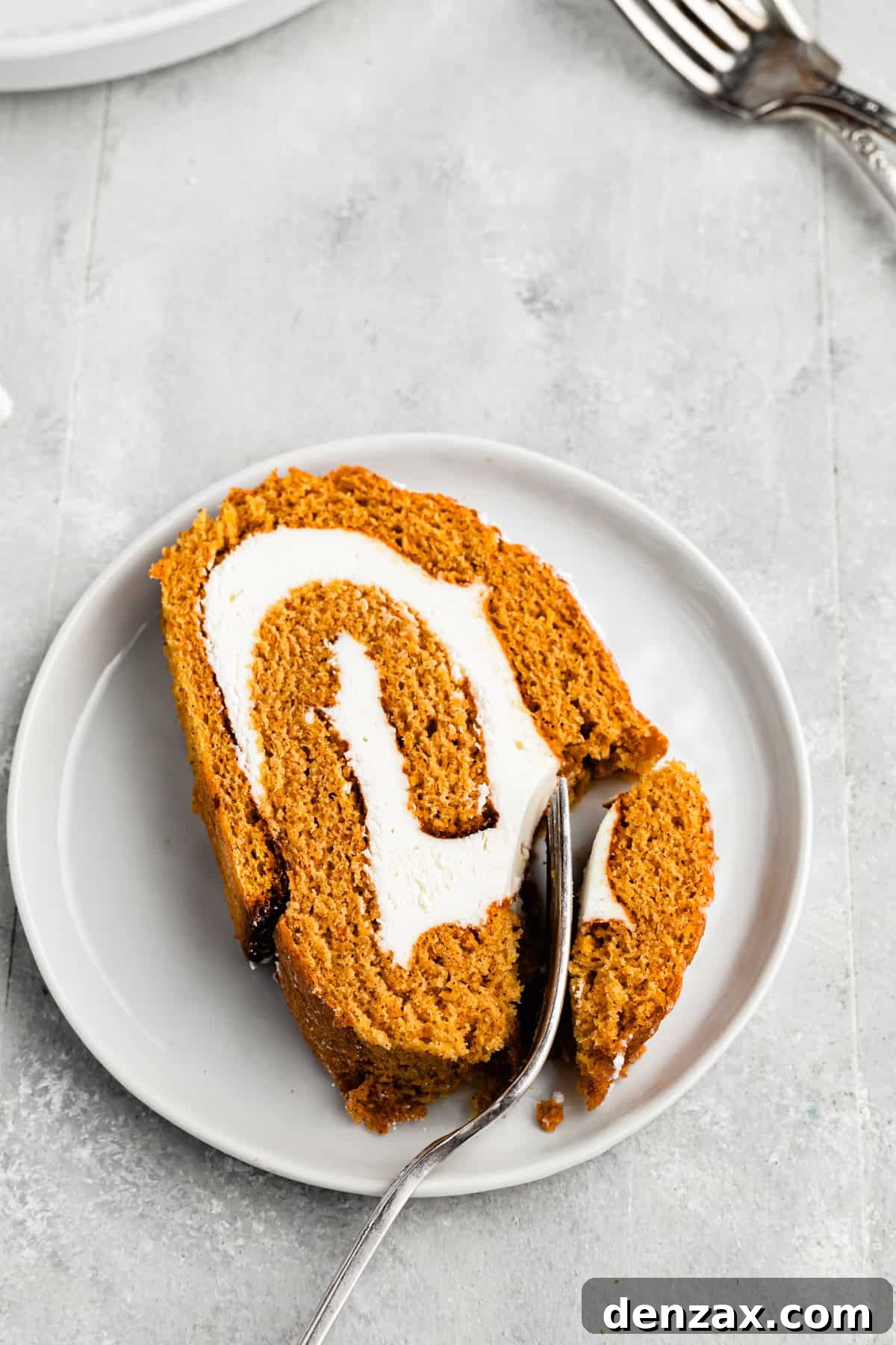 A fork cutting into a roll cake.