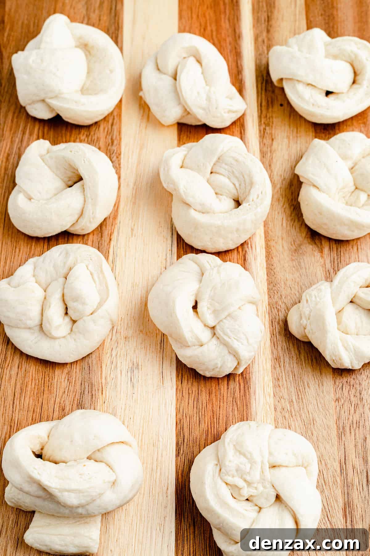 Easy Homemade Garlic Knots Recipe — Soft, Buttery & Ready in 30 Minutes 5 Unbaked and unseasoned strips of pizza dough, shaped into knots on a work surface.