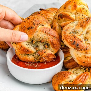 Easy Homemade Garlic Knots Recipe — Soft, Buttery & Ready in 30 Minutes 8 dipping garlic knots in marinara sauce.