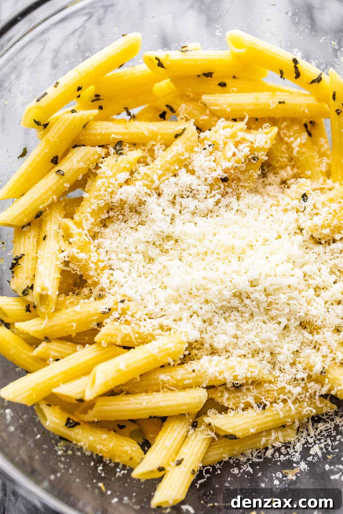 Crispy Pasta Chips: Air Fryer or Oven Recipe Guide 4 bowl with boiled pasta and a mount of parmesan cheese in the middle of it.