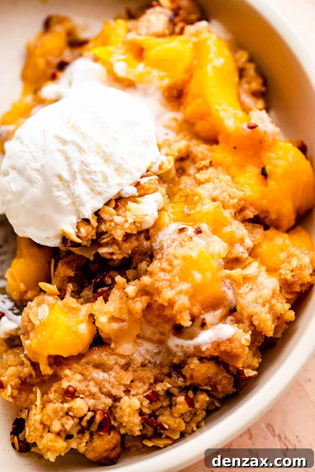 Perfect Peach Crisp Recipe: Easy Summer Dessert with Oats 7 bowl of peach crisp topped with a scoop of vanilla ice cream