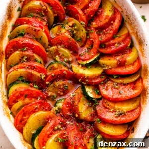 overhead shot of zucchini, tomato, and potato slices arranged accordion style in a baking dish.