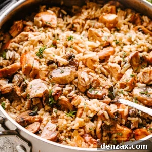 Chicken, mushrooms, and rice in a pan being stirred