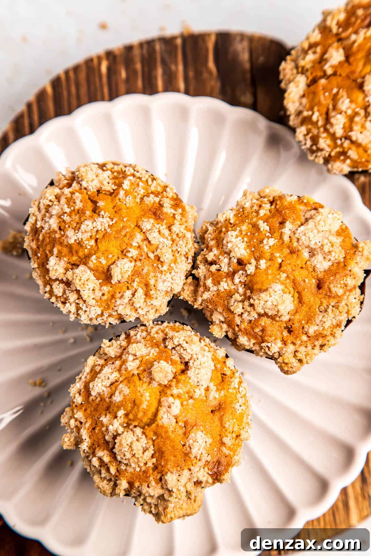 Homemade Pumpkin Muffins from Scratch — Moist Fall Recipe 4 overhead shot of three pumpkin muffins on a white plate.