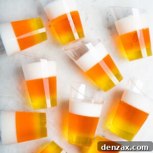 10 candy-corn jello shots scattered on a white table.