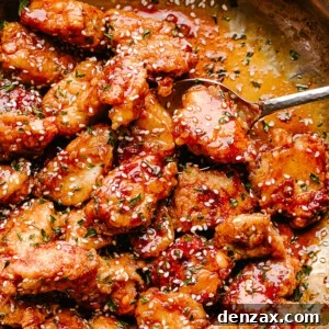 Crispy Honey Sesame Chicken being stirred in a pan
