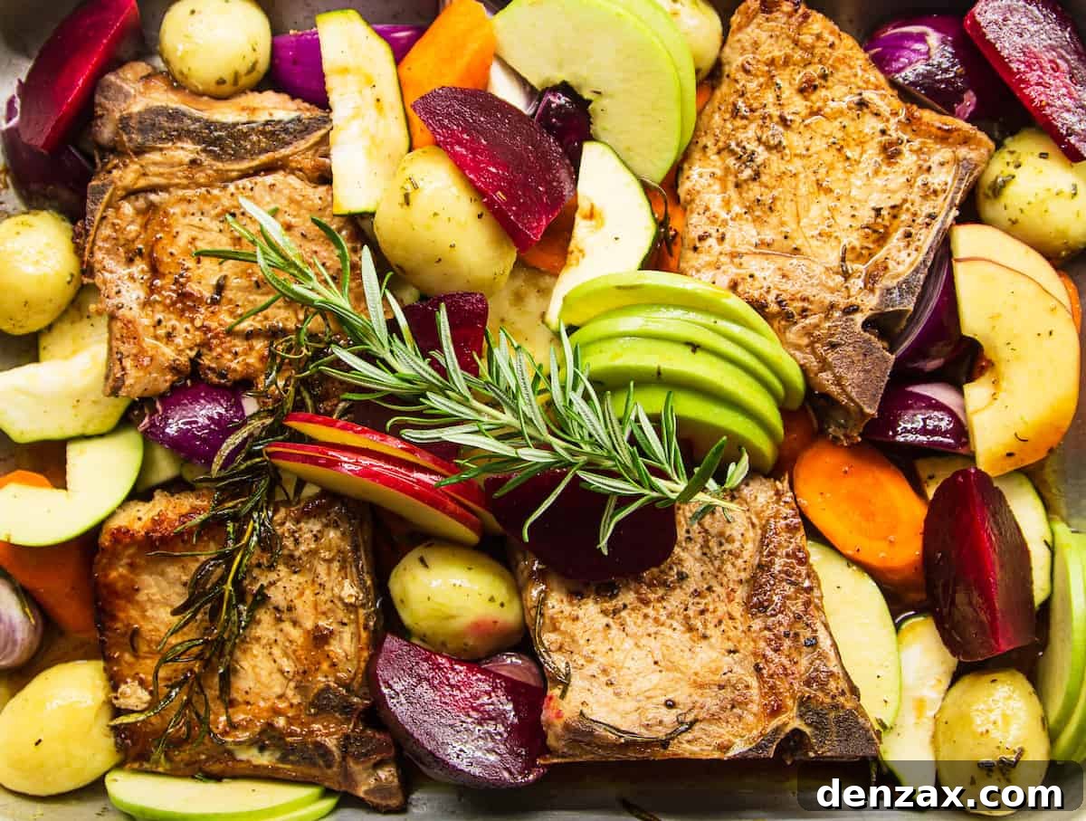 Roasted Pork Chops with Apples and Winter Vegetables 8 A close-up overhead shot of the baking dish with pork chops, apples, and vegetables cooked with apple juice and rosemary.