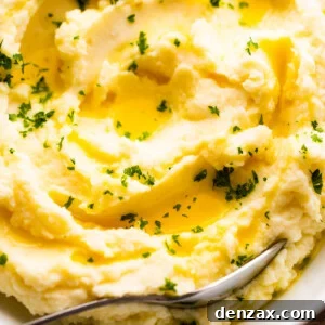 close up overhead shot of creamy mashed potatoes garnished with melted butter and parsley
