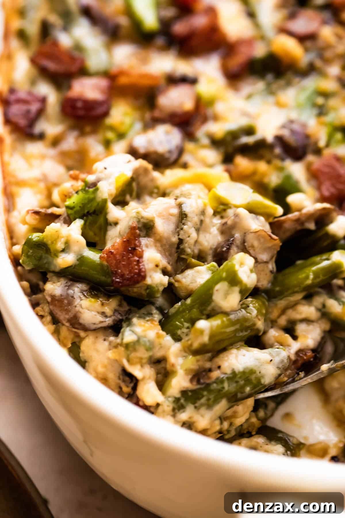close up shot of a large spoon scraping out green bean casserole.