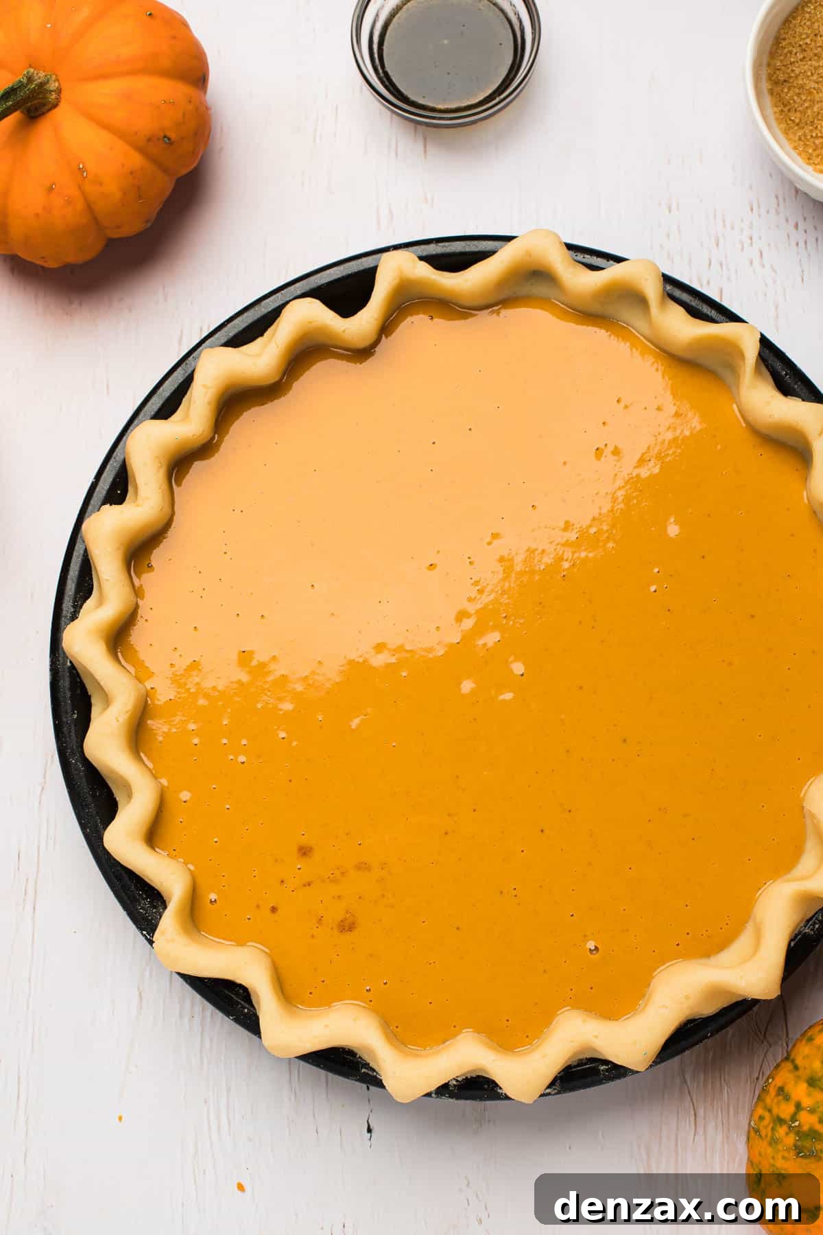 This homemade and easy Pumpkin Pie recipe is a holiday favorite! Everyone will love the tender pie crust, warm spices, and dulce de leche pumpkin filling. pie shell filled with pumpkin pie filling.